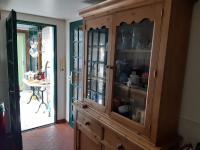a wooden cabinet with glass doors in a room at les orchidees sauvages in Touffreville-la-Corbeline