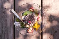 um prato de vidro com comida sobre uma mesa de madeira em Am Pfarrhof - Gourmethotel by Harald Irka em Sankt Andrä-Höch