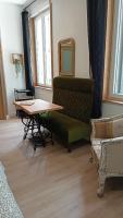 Zimmer mit einer Bank, einem Tisch und einem Spiegel in der Unterkunft Le Raffiné in Millau