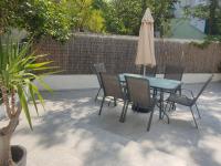 a table and chairs and an umbrella on a patio at ENDLESS BLUE Dream Villa in Paleo Tsifliki