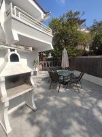 a patio with a table and chairs and an umbrella at ENDLESS BLUE Dream Villa in Paleo Tsifliki