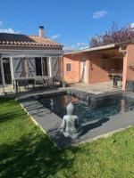 a statue sitting in a pool in a yard at Charmante villa équipée, piscine in Le Soler
