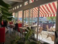 Un restaurante con mesas y sillas y un gran ventanal. en Logis Central Hôtel - Restaurant & Spa, en Bort-les-Orgues