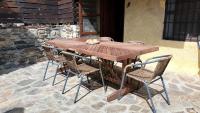a wooden table and chairs on a patio at Maison en Cerdagne avec belle vue in Enveitg