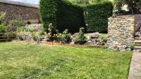 a garden with a stone wall and flowers at Maison en Cerdagne avec belle vue in Enveitg