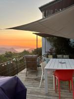 a wooden deck with a table and chairs and an umbrella at Casa Costa in Barbaggio