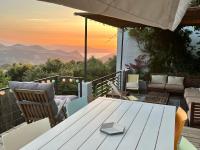 a table and chairs on a patio with a view of the mountains at Casa Costa in Barbaggio