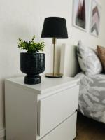 a white dresser with a lamp and a plant on it at Chambre privée avec petit salon extérieur in Bordeaux