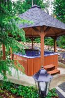 a large wooden gazebo with a bench and a table at Panorama Górska Wisła Resort & SPA in Wisła
