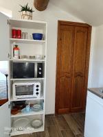 a kitchen with a microwave on a shelf next to a door at Cadre d&#39;exception in Orange