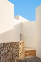 a stone wall next to a white building at Can Jaume by Ocean Drive in Ibiza Town