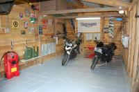two motorcycles parked in a room with wooden walls at Le Buisson B&amp;B in Gouvy
