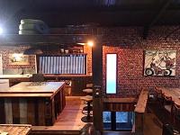 a restaurant with wooden tables and a brick wall at Magnifique loft atypique proche gare et bord de rivière in Le Mans
