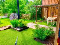 a backyard with a table and chairs and a grass yard at Magnifique loft atypique proche gare et bord de rivière in Le Mans