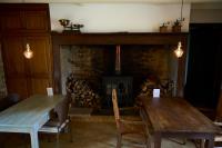 ein Wohnzimmer mit 2 Tischen und einem Kamin in der Unterkunft La ferme de Roquedure in Montfaucon