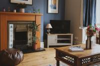 Una sala de estar con chimenea y televisión. en A cosy garden flat in a quiet area close to the city centre, en Bristol