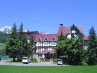 Una casa grande con un reloj en la parte delantera. en Rosenheim Hakuba, en Hakuba