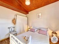 a bedroom with a white bed with purple pillows at Ti Case l&#39;Ermitage, classée 2 étoiles -100 m2 avec piscine - Saint-Gilles in Saint-Gilles-les-Bains