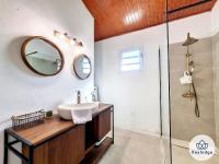a bathroom with a sink and a mirror at Ti Case l&#39;Ermitage, classée 2 étoiles -100 m2 avec piscine - Saint-Gilles in Saint-Gilles-les-Bains