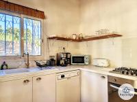 a kitchen with a sink and a microwave at Ti Case l&#39;Ermitage, classée 2 étoiles -100 m2 avec piscine - Saint-Gilles in Saint-Gilles-les-Bains