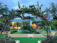 a garden with a arch with pink flowers at Xin Yuan My Dream Castle in Dongshan