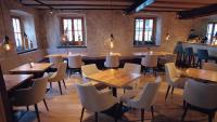 um restaurante com mesas e cadeiras de madeira e janelas em Hotel Restaurant Schwarzer Adler em Bad Saulgau