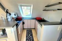 a small kitchen with white cabinets and a window at Studio Design Sous Toits IntraMuros Vue Cathédrale in Vannes