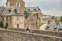 a woman standing on the wall of a castle at Studio Design Sous Toits IntraMuros Vue Cathédrale in Vannes