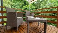 a deck with two chairs and a table and an umbrella at Holiday house Kajfes in Brod na Kupi