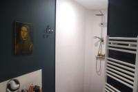 a bathroom with a painting of a woman on the wall at Un jardin en ville in Nantes