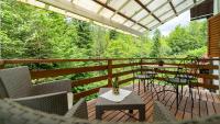 a deck with tables and chairs and a view of trees at Holiday house Kajfes in Brod na Kupi