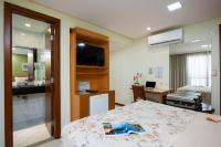 a hotel room with a bed and a bathroom at Hotel Santorini in Vila Velha
