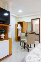 a living room with a bed and a dining room at Hotel Santorini in Vila Velha