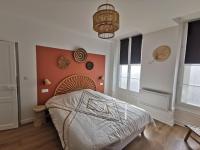 a bedroom with a large bed with an orange wall at Clos Léonie - appartement 68m2 lumineux avec sauna in Givry