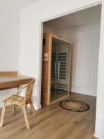 a room with a wooden table and a glass refrigerator at Clos Léonie - appartement 68m2 lumineux avec sauna in Givry