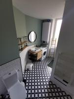 a bathroom with a white sink and a black and white tile floor at Clos Léonie - appartement 68m2 lumineux avec sauna in Givry