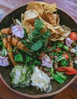 um prato de comida com legumes e batatas fritas sobre uma mesa em Sandi Hotel em Paraty