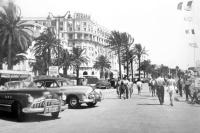 a group of people walking down a street with cars at Palais Miramar - Suite White Jardin - 20m Plage in Cannes