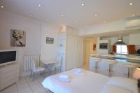 a room with a kitchen and a living room with a couch at Palais Miramar - Suite White Jardin - 20m Plage in Cannes