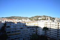 a large white building with mountains in the background at Palais Miramar - Suite White Jardin - 20m Plage in Cannes