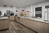 a restaurant with a counter and aasteryasteryasteryasteryasteryasteryasteryasteryastery at Embassy Suites Winston-Salem in Winston-Salem