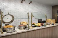 a buffet with bowls of food on a counter at Embassy Suites Winston-Salem in Winston-Salem