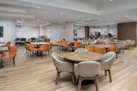 a restaurant with tables and chairs and a cafeteria at Embassy Suites Winston-Salem in Winston-Salem