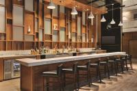 un bar con fila di sgabelli da bar di Embassy Suites by Hilton Richmond a Richmond