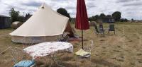 a tent in a field with a table and chairs at La tente saharienne du Perche .Chevaux. 