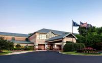 un edificio de oficinas con dos banderas delante en The Desmond Hotel Malvern, a DoubleTree by Hilton, en Malvern