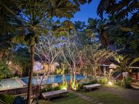 un complejo con piscina y 2 bancos en Astuti Gallery Homestay, en Yogyakarta