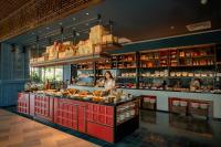 a woman standing behind a counter in a restaurant at Citadines Marina Halong in Ha Long