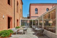 un patio al aire libre con sillas, mesas y ventanas en Hyatt Centric Murano Venice, en Murano
