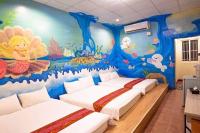 two beds in a room with a mural at Fumigate Hotel in Hengchun South Gate